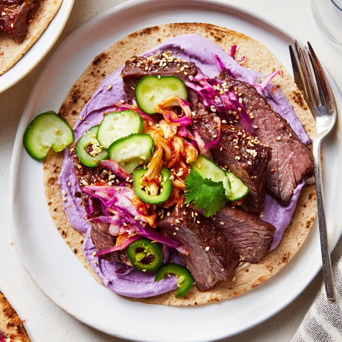 Vibrant Global Street-Food Fusion Tacos topped with ube crema and fresh veggies.  