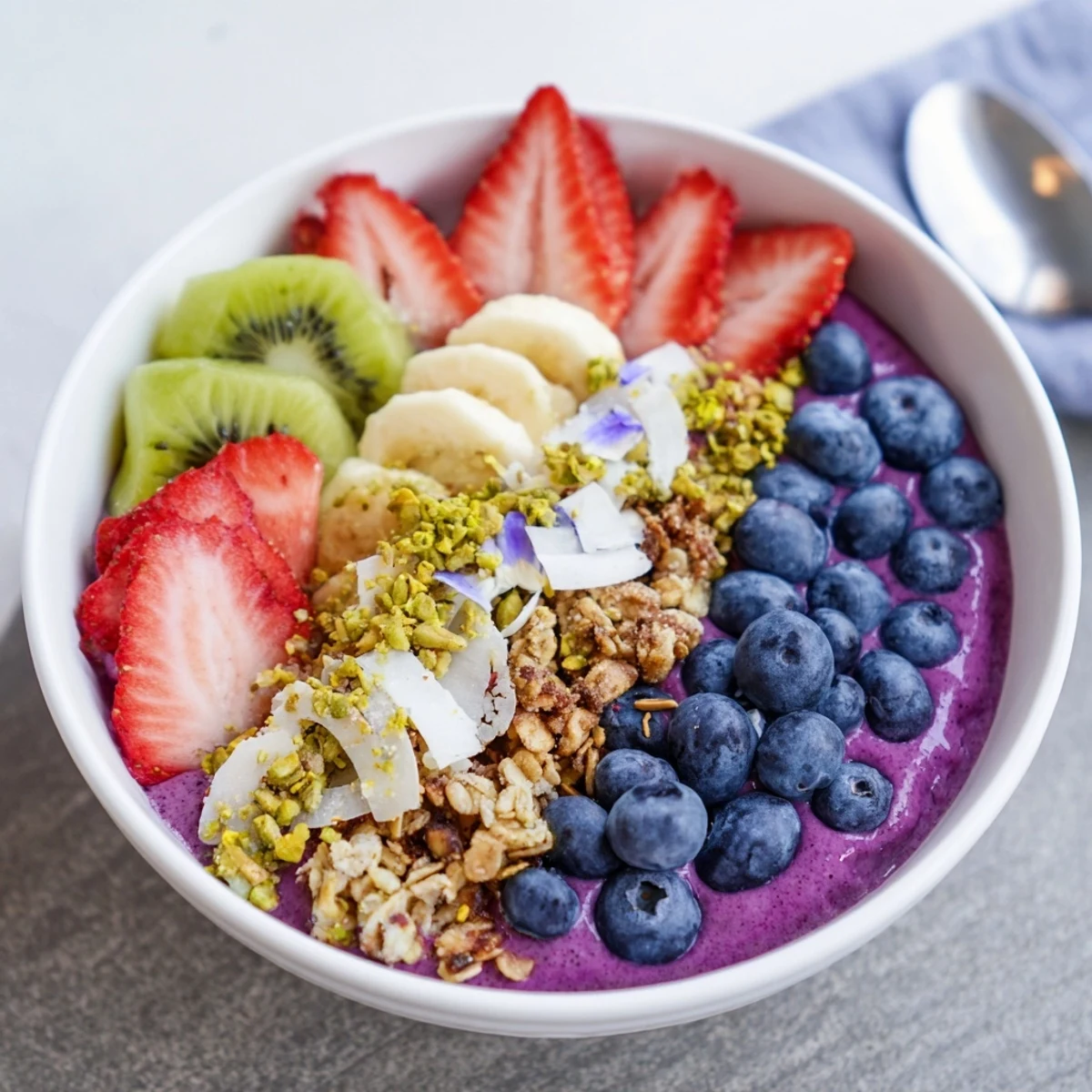 Nutritious breakfast smoothie bowls topped with granola, kiwi, and edible flowers for added flair.