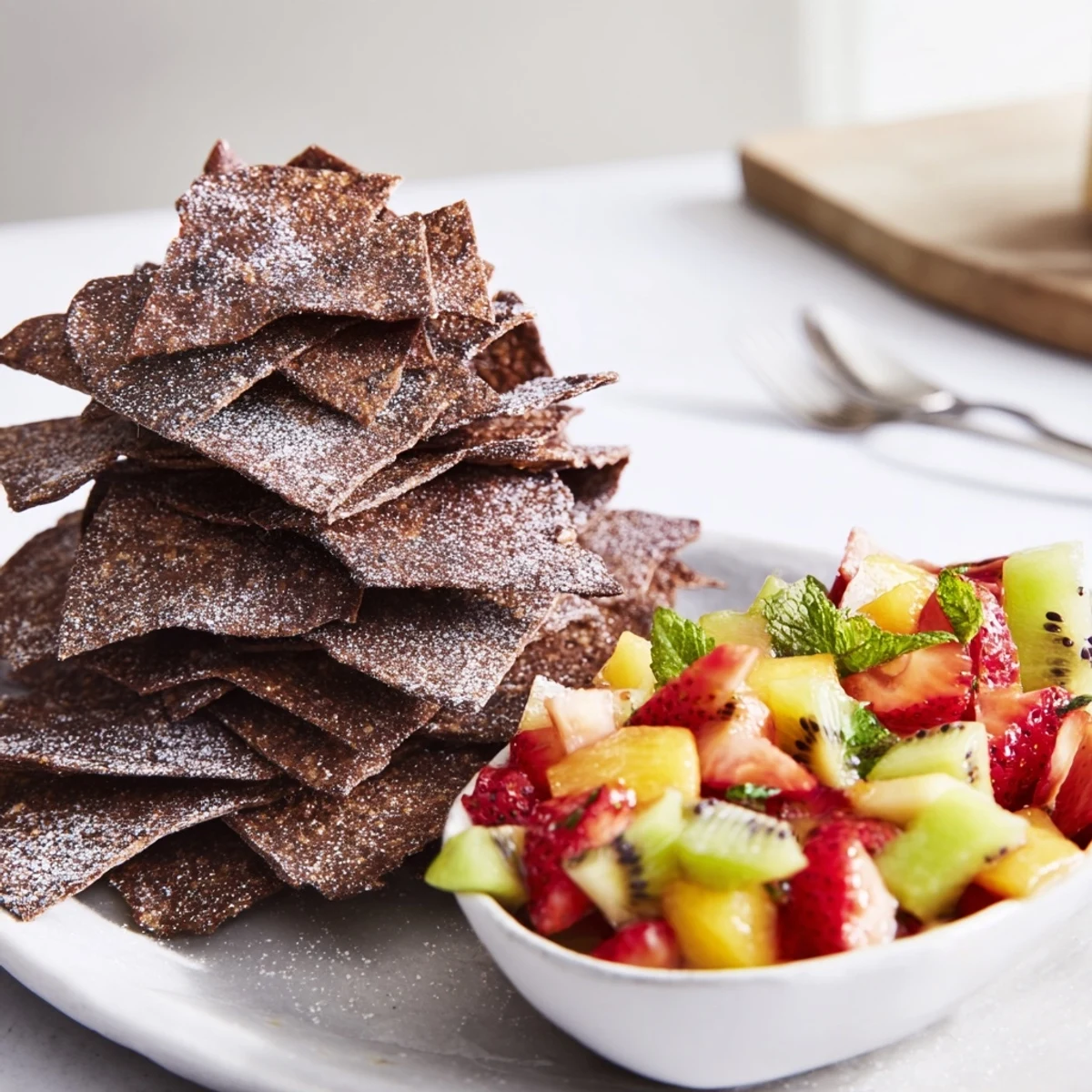 Crispy chocolate tortilla chips with vibrant fruit salsa for a fun dessert.  