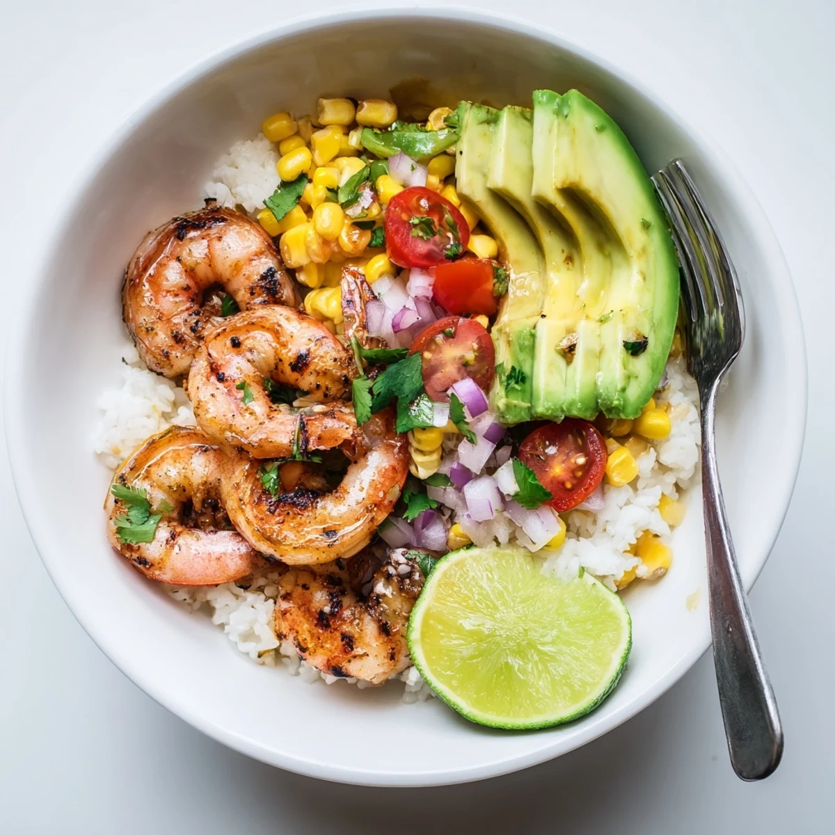 Juicy grilled shrimp bowl topped with creamy avocado corn salsa, perfect for summer lunches.  