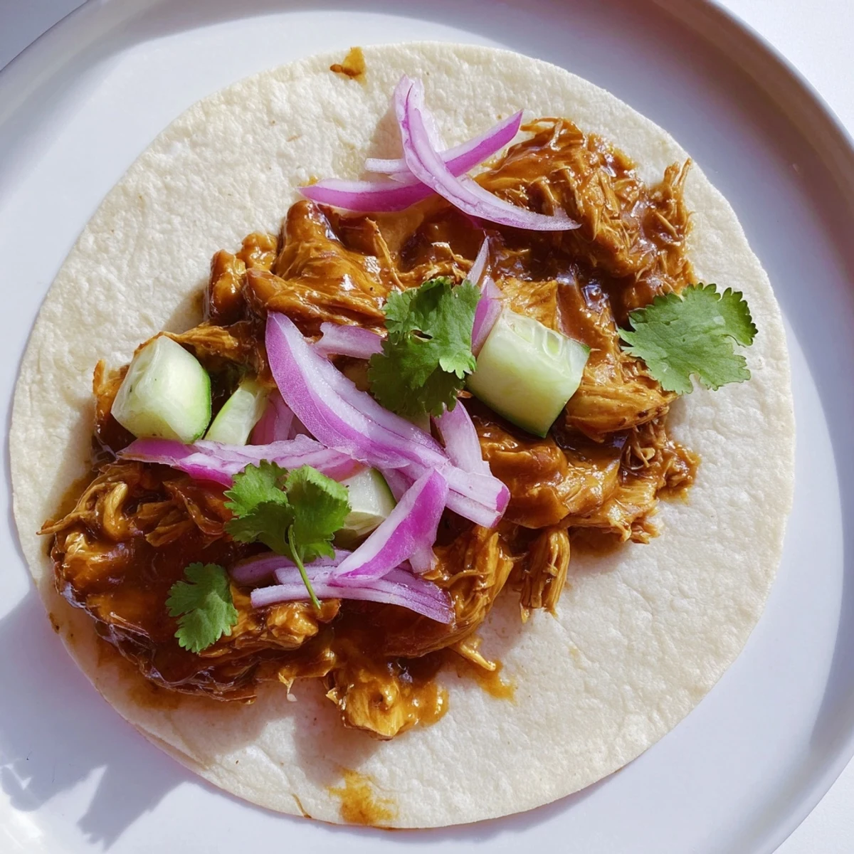 Close-up of hearty sticky chicken tikka masala tacos, piled high with fresh toppings for a delightful meal.