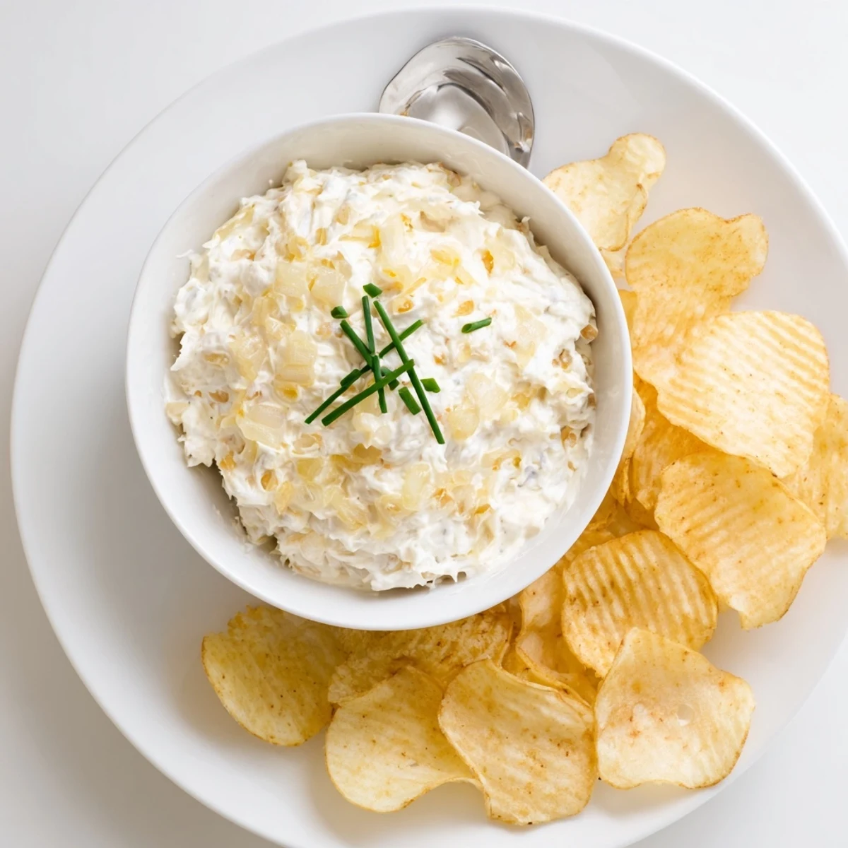 Crisp potato chips with creamy onion dip, a perfect party snack, ready to enjoy together.