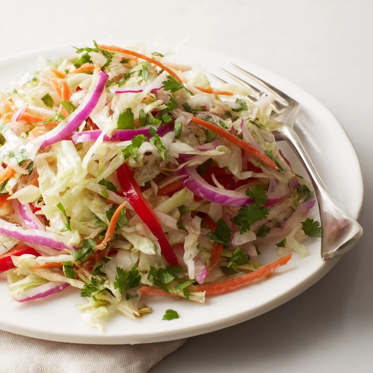 A warm bowl of the Cooked and Loved Cabbage Salad with sautéed green cabbage, shredded carrots, and red bell peppers.  