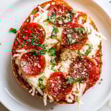 Golden, savory mini pepperoni pizza bagels, fresh from the oven, offering a delightful cheesy aroma.