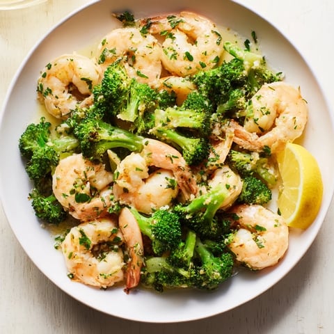 Golden-hued Lemon Butter Shrimp & Broccoli, a quick and delicious weeknight dinner, sizzling in a pan.