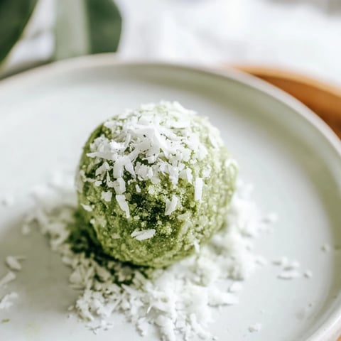 Earthy green Coconut Matcha Snowball Fat Bombs rolled in coconut, perfect for a keto snack.