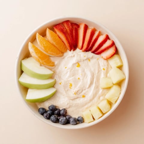 Cream cheese fruit dip, a smooth, white dip surrounded by vibrant, colorful berries and fruit slices.