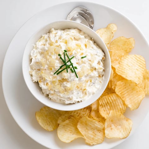 Crisp potato chips with creamy onion dip, a perfect party snack, ready to enjoy together.