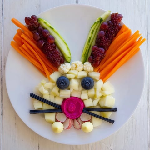 Festive bunny silhouette appetizer platter showcases fresh berries and creamy cheeses for spring gatherings.