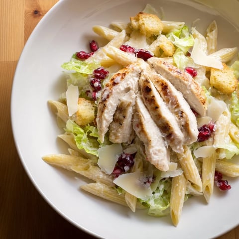 Chicken Caesar Pasta with pomegranate, a vibrant salad with grilled chicken and creamy dressing, is served.