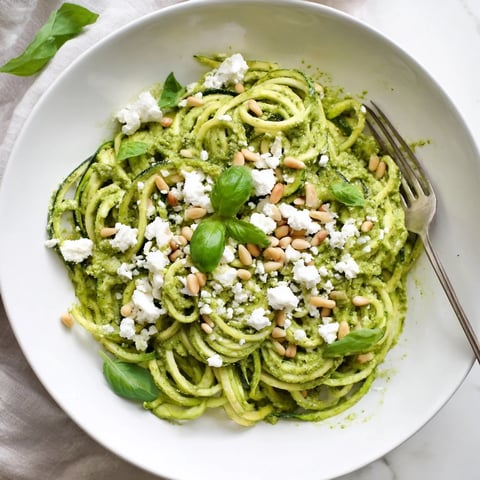 Freshly spiralized zucchini noodles tossed in a vibrant tomato basil sauce and topped with Parmesan cheese.