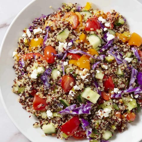 Close-up of colorful Rainbow Quinoa Salad; the lemon vinaigrette glistens on the quinoa.