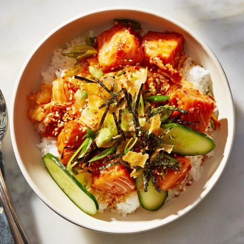 Flavorful crispy salmon rice bowl with fresh avocado, garlic, and zesty toppings.  