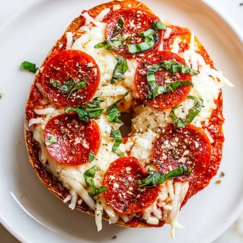 Golden, savory mini pepperoni pizza bagels, fresh from the oven, offering a delightful cheesy aroma.