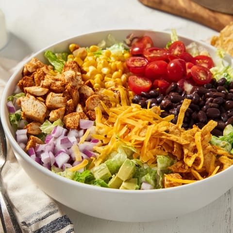 Fresh Tex-Mex Chicken Taco Chopped Salad served with lime wedges and a side of salsa ranch dressing for a quick, vibrant meal.  