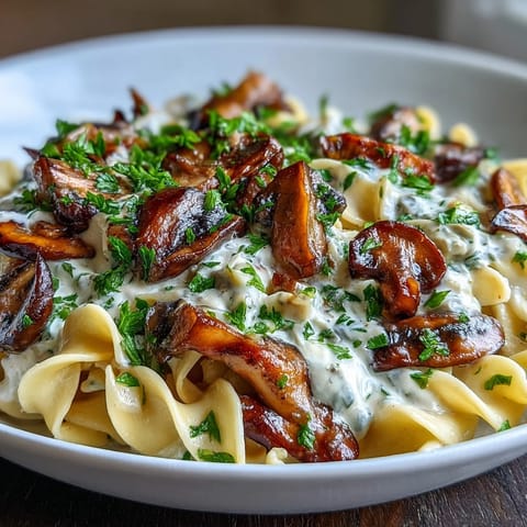 A skillet of Creamy Mushroom Stroganoff featuring sautéed mushrooms and a luscious, tangy miso-infused sauce ready to be served over pasta.