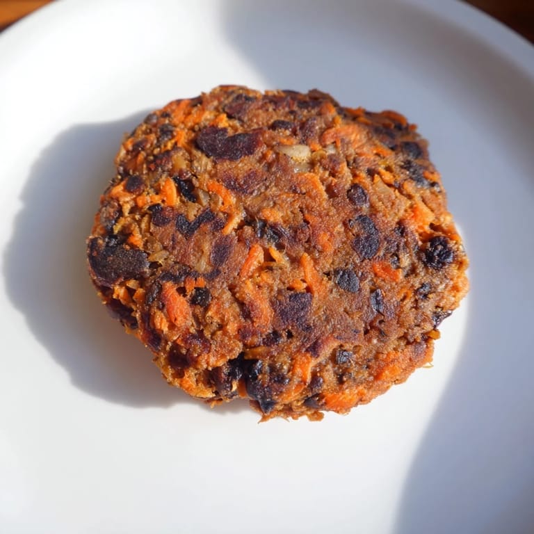 A close-up shot of crispy black bean burgers sizzling in a pan, infused with savory spices.