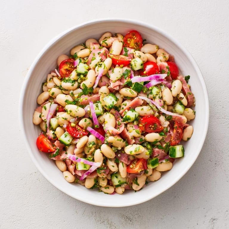 This hearty dense bean salad with prosciutto shows tender beans, veggies, and flavorful dressing ready.