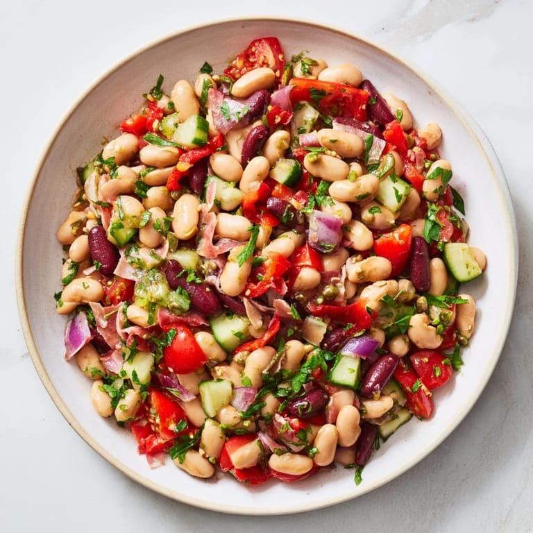 Close-up of a vibrant dense bean salad with prosciutto, perfect for a light, delicious lunch.