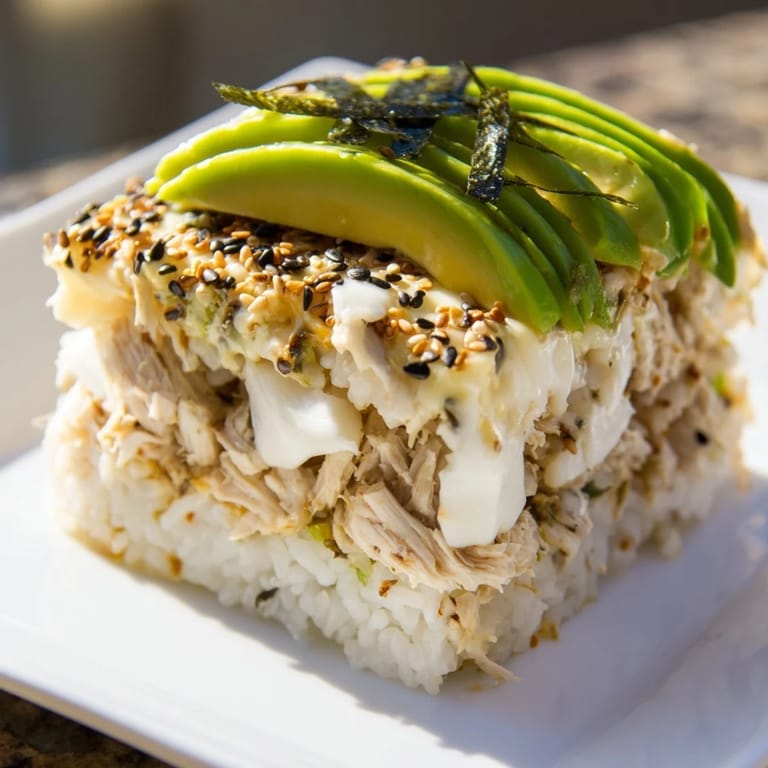 A hearty Chicken Sushi Bake with melted cheese, avocado slices, and crispy nori strips.