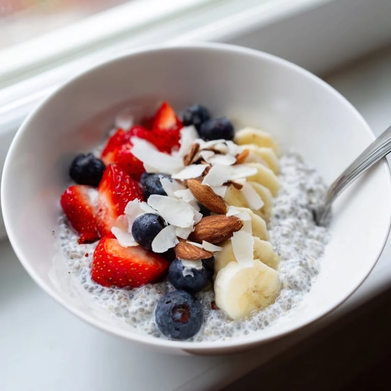 Thick homemade chia seed pudding topped with crunchy nuts and shredded coconut.
